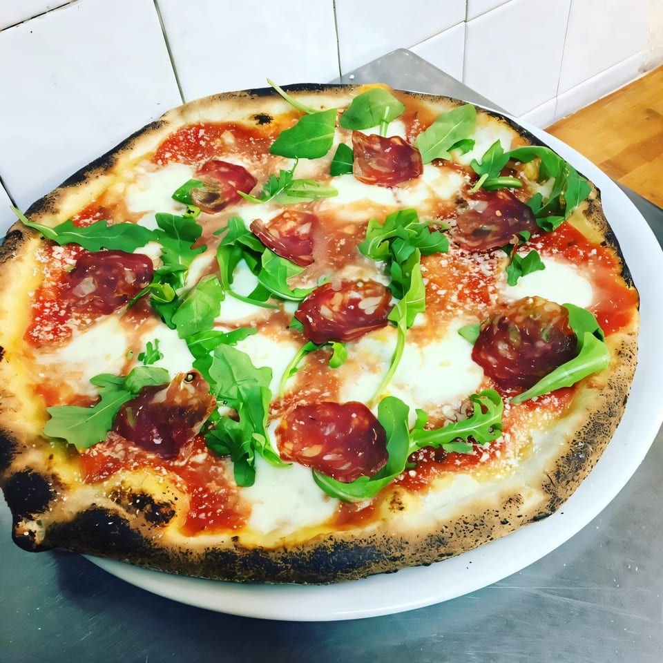 Alfredo's Pizza: a whole Italian pizza with salami, mozzarella, tomato sauce, arugula, and parmesan.